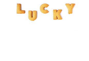 The word LUCKY spelled with alphabet shaped biscuits, isolated on white background with free space for text and design  