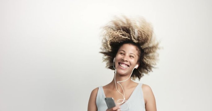 black woman with afro hair dancing and smiling