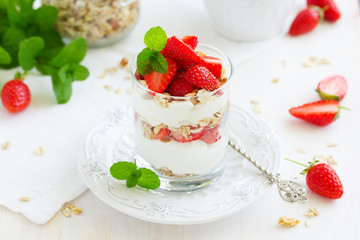 Dessert in a glass with granola, yogurt and strawberries. Useful breakfast.