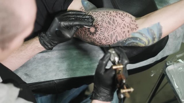 The master does the tattoo of the man on his arm 4k
