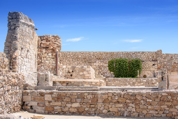 Fototapeta premium Stone wall and blue sky with clouds, background free space for text