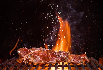 Cercles muraux Grill / Barbecue Beef steaks on the grill with flames