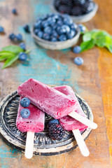 Fresh summer wild blueberries and  brambleberry, home made sorbet ice cream popsicles on stone plate