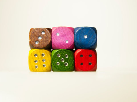 Isolated wooden game dices with numbers in six colors