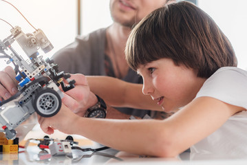 Obraz premium Concentrated male kid repairing technical toy