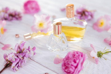 Fototapeta na wymiar Bottles of perfume with flowers
