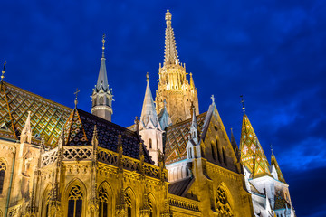 Fototapeta na wymiar View of the Matthias Church during blue hour, roman catholic church located in Budapest, Hungary inside Fisherman's Bastion at the heart of Buda's Castle