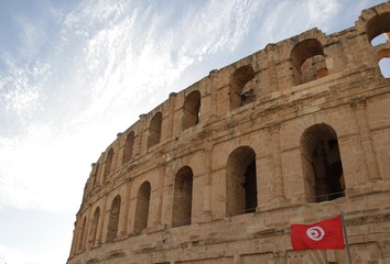 View of El Jem and the flag of Tunisia/ View of the Roman Amphitheater of El Jem, sky, clouds and the flag of Tunisia