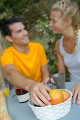 Man reaching for apple from fruit bowl