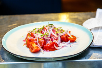 Salad of tomatoes and onions lying on the plate.