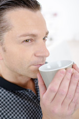 Contemplative man drinking from cup