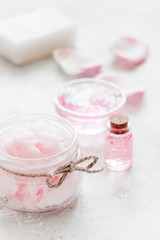 body treatment with rose petals and cosmetic set white desk background