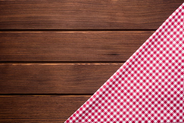 Obraz premium Napkin in a red and white cage on a wooden background, texture, copy space