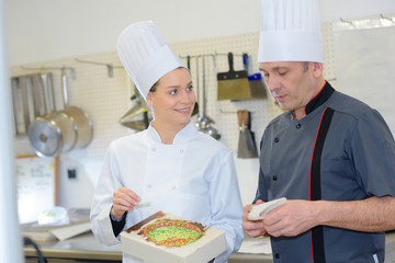 Male and female chefs, woman holding open box