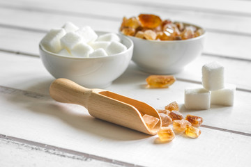 sugar cubes on white wooden table background close up