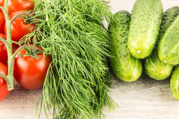 Cucumber, tomato, pepper and fennel on a white wooden background close up.