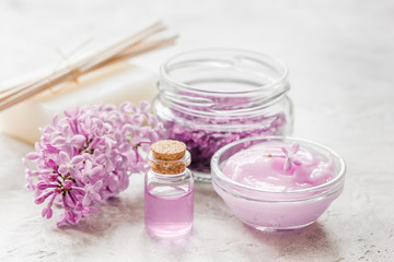 lilac natural cosmetic set for spa with salt stone table background