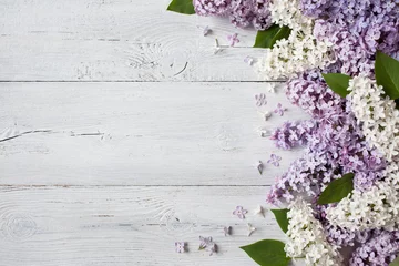 Foto op Plexiglas Een houten ondergrond met bloeiende lila takken © tachinskamarina