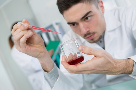 Male Scientist Using Pipette