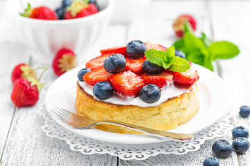 Delicious berry cheesecake with fresh strawberry and blueberry on white background