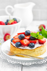 Delicious berry cheesecake with fresh strawberry and blueberry on white background