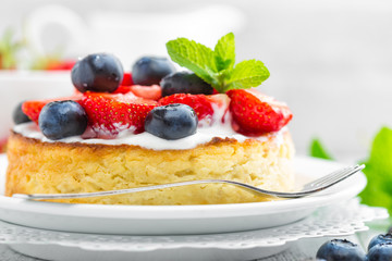 Delicious berry cheesecake with fresh strawberry and blueberry on white background
