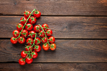 Fototapeta na wymiar Fresh cherry tomatoes on twigs on wooden table, top view
