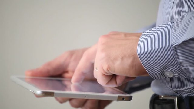 side view of digital tablet computer in hands, typing close up