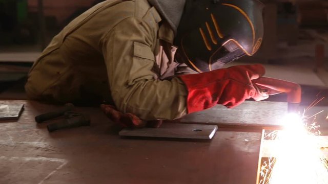 A worker manually cuts metal using manual plasma torch