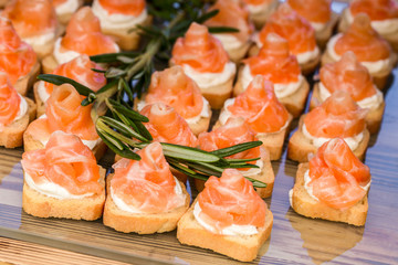 mini canapes with smoked salmon and rosemary sprig.