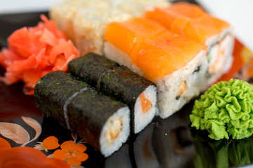  Sushi rolls with raw salmon.Traditional japanese food..Philadelphia Sushi on a black plate close-up