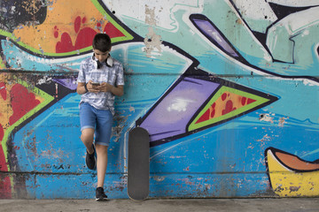 child with the mobile phone and the skateboard street
