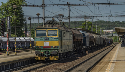 Obraz premium Green electric engine with cargo train