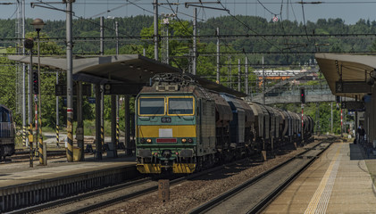 Fototapeta na wymiar Green electric engine with cargo train