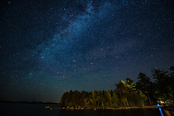 Maine- Milkyway shining in the night sky over trees