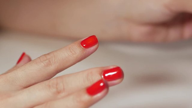 Female hands manicure with red nails close up view on white background. Classic color manicure.