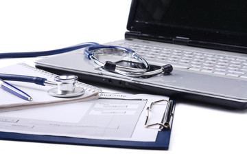 Fototapeta na wymiar Stethoscope with clipboard and laptop on the desk