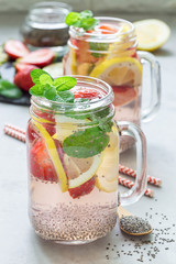 Healthy detox chia seed drink with strawberry, lemon and mint in a glass jar, vertical