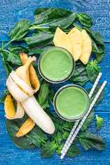 Detox green smoothie with spinach, pineapple, banana and yogurt, vertical, top view