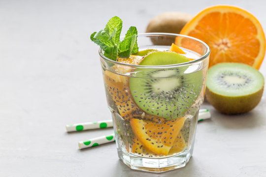 Healthy detox chia seed drink with kiwi, orange and mint in a glass, horizontal, copy space