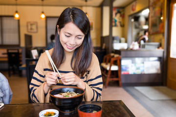 Woman enjoy japanese ramen in restaurant