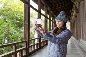 Woman taking photo in japanese architecture