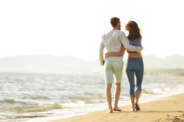 happy couple waling on the beach and having fun