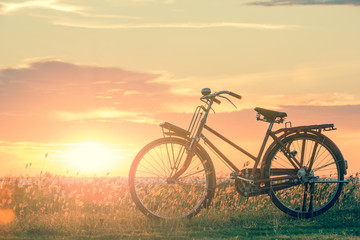 Naklejka na ściany i meble bicycle silhouette at the sunset or sunrise