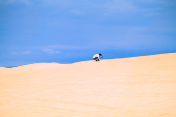 Fototapeta na wymiar White Desert At Mui Ne / Mui Ne, Vietnam - May 26, 2017: Unidentified People In Sunny Day With Blue Sky On Sand Dune White Desert In Mui Ne Vietnam.