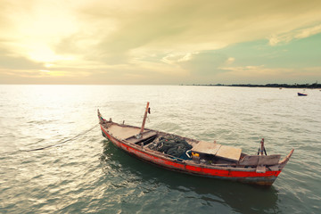 Naklejka na ściany i meble Old fishing boat on the sea coast of Thailand.