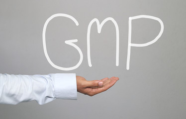 Hand of businessman and hand drawn text GMP system.