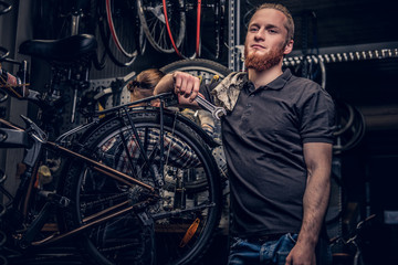 Fototapeta na wymiar Bicycle mechanic in a workshop with bike parts and wheel on a background.