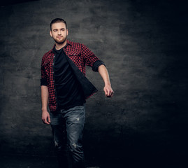 Bearded hipster male dressed in a red fleece shirt over grey background.