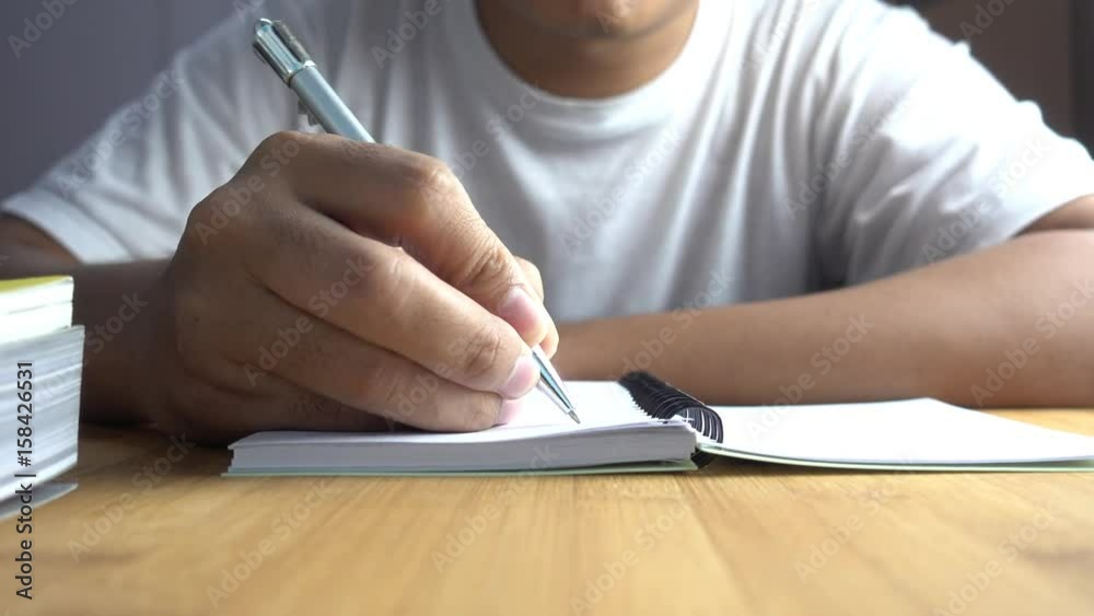 Poster hand pen writes in a notebook